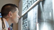 Healthcare provider analyzing diagnostic images hanging on a wall